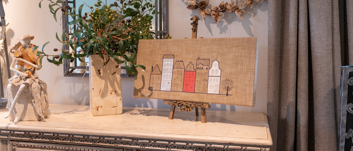 red and white appliqué cartoon house embroidered onto brown linen