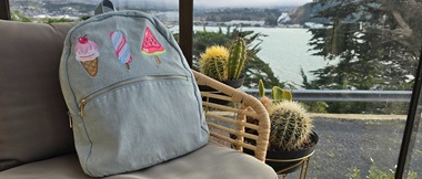 Denim backpack with three appliqué ice lollies embroidered on.