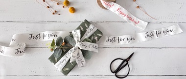 PrintModa Studio personalised printed ribbons on green gift wrap