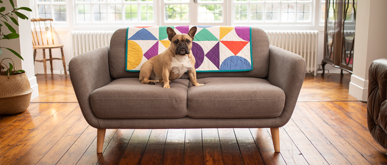 geometric primary colour quilt on grey sofa