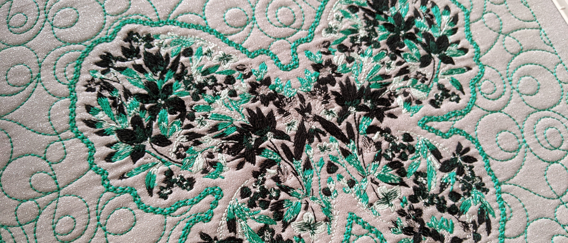 Turquoise floral butterfly embroidery with quilted background