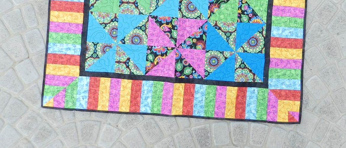 Colourful quilt on paving stones