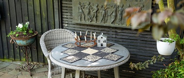 irregular shaped small black and tan quilt on garden table