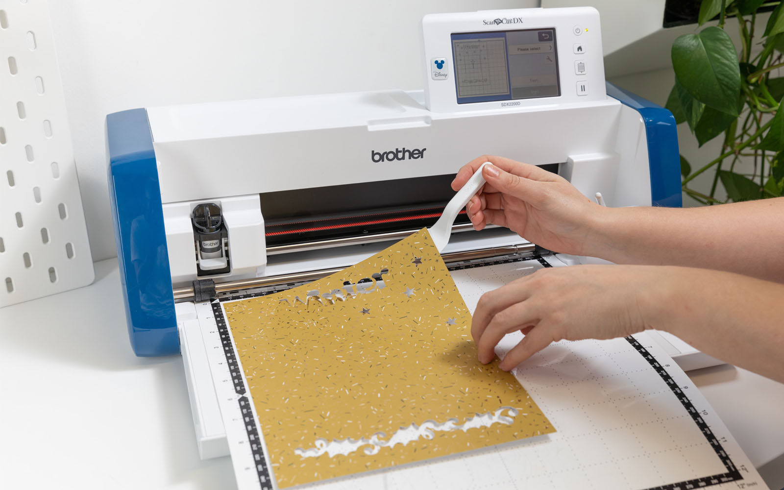 Hands removing yellow card from Brother ScanNCut cutting mat