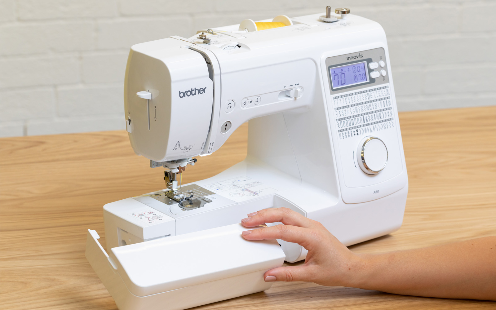 hand removing accessories compartment from Brother A80 sewing machine
