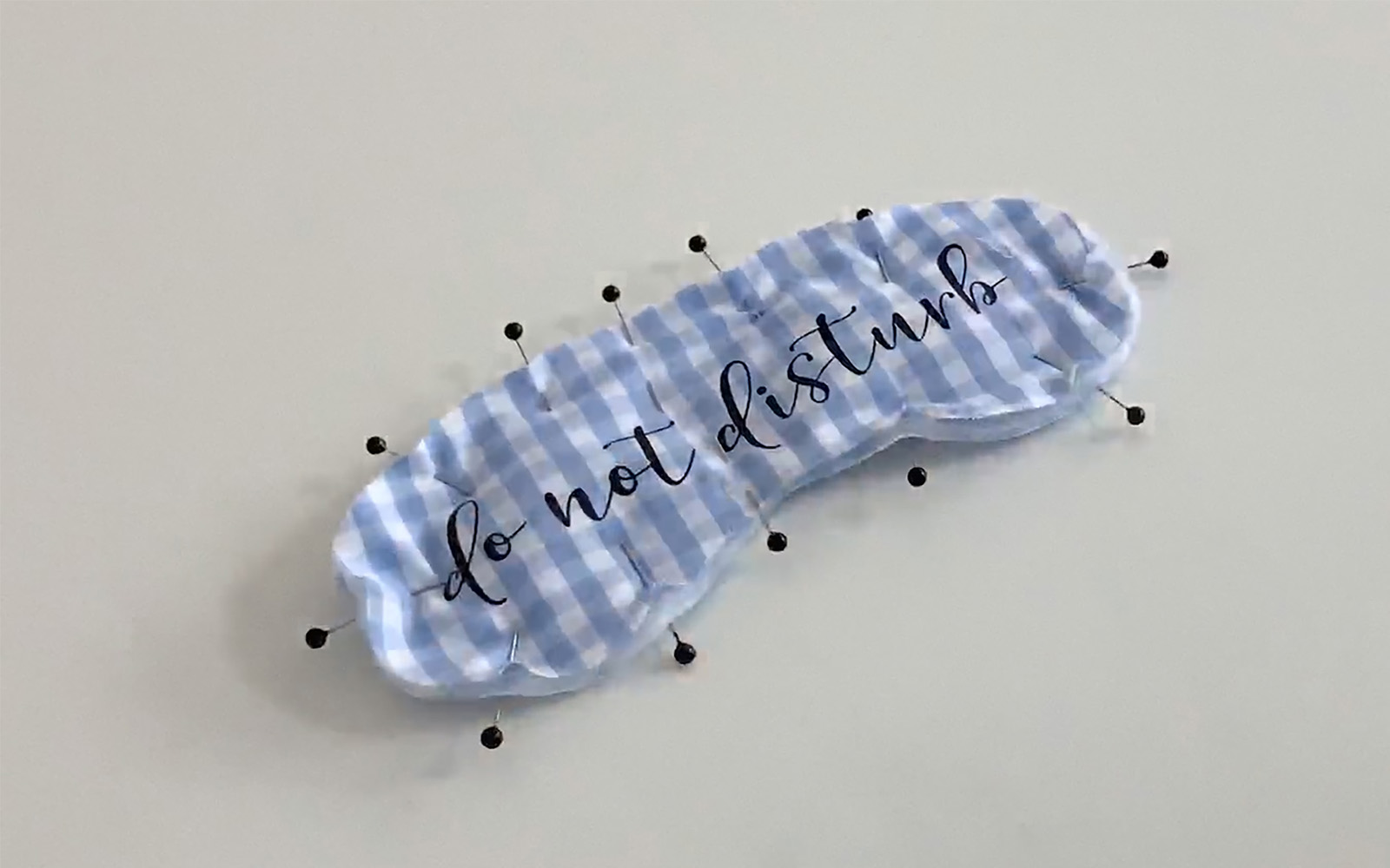 three layers of blue cotton sleep masked pinned together for sewing