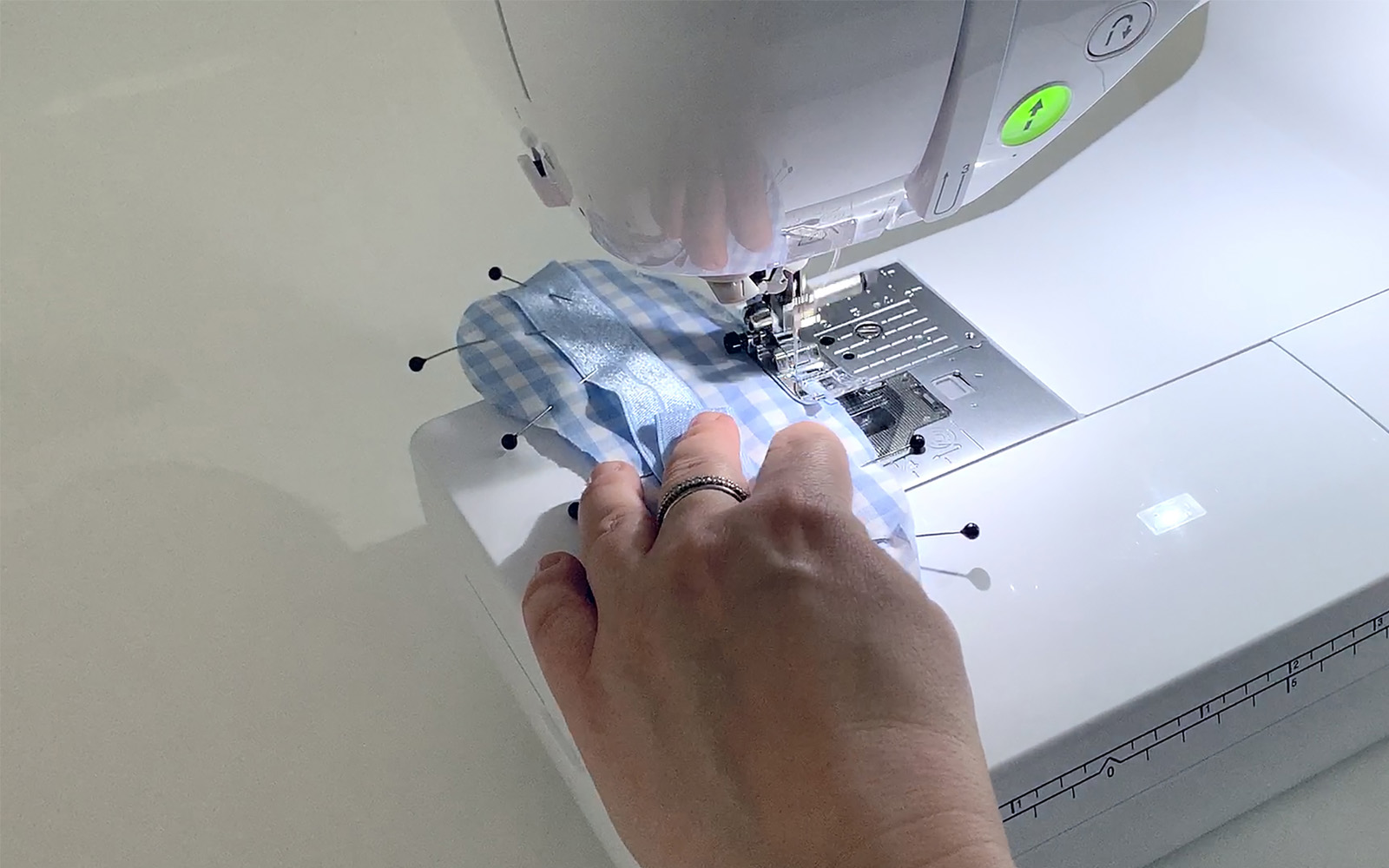 hands sewing blue sleep mask on Brother sewing machine