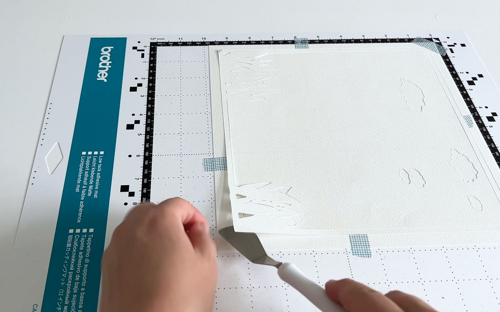 Card being removed from Brother low tack ScanNCut mat using spatula