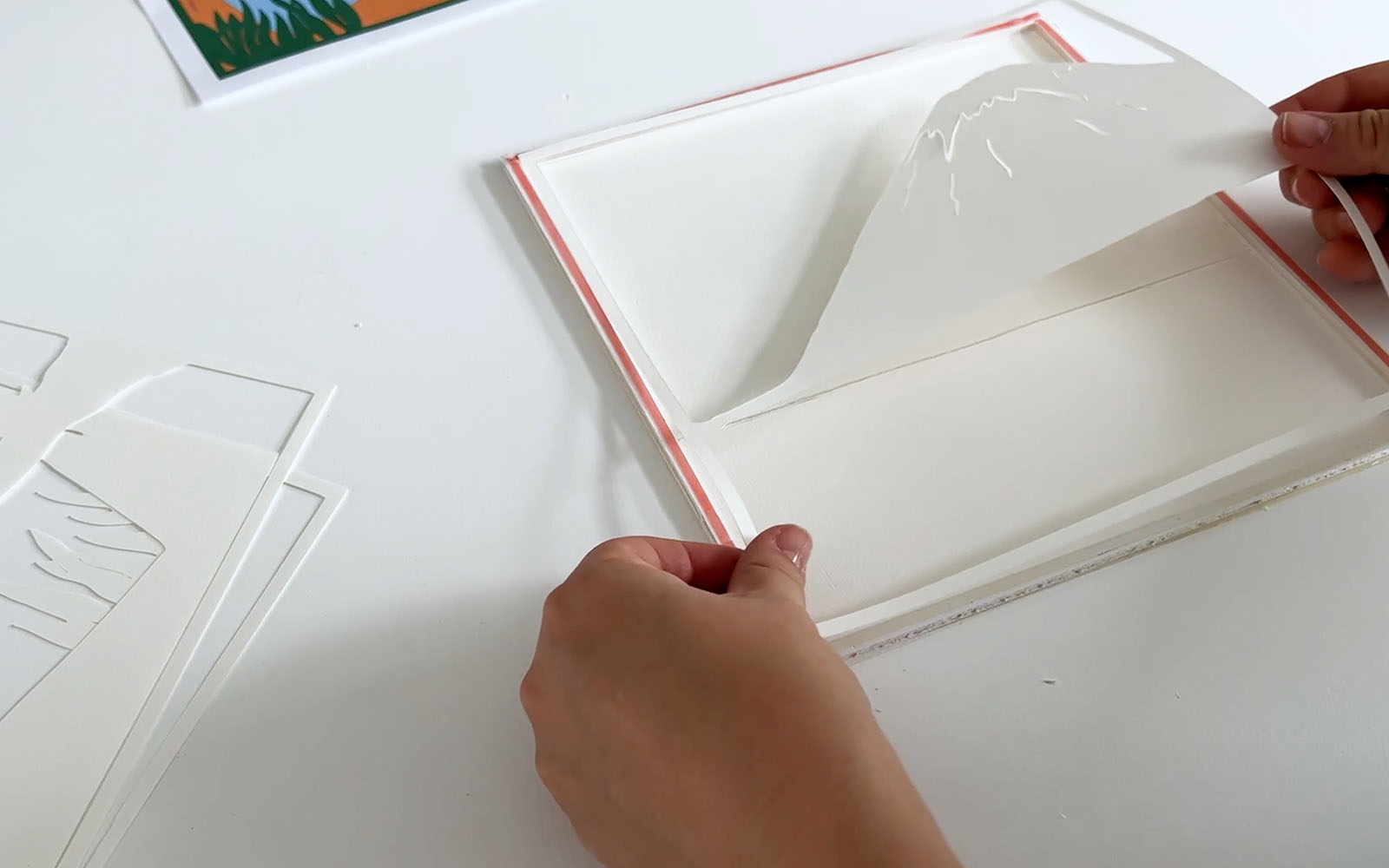 Smaller detail pieces are adhered to background layers of lightbox