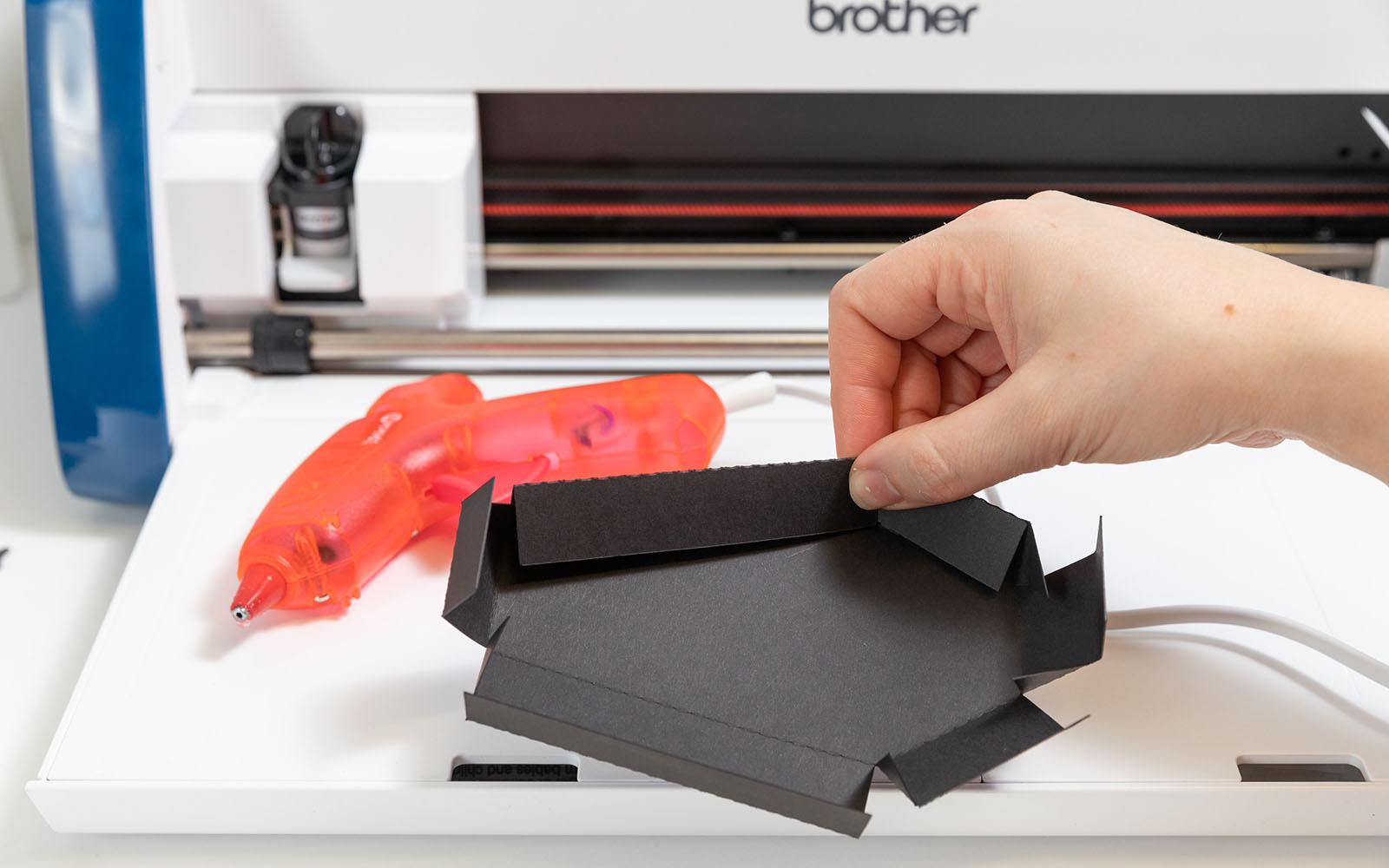 black card coffin being glued together with glue gun