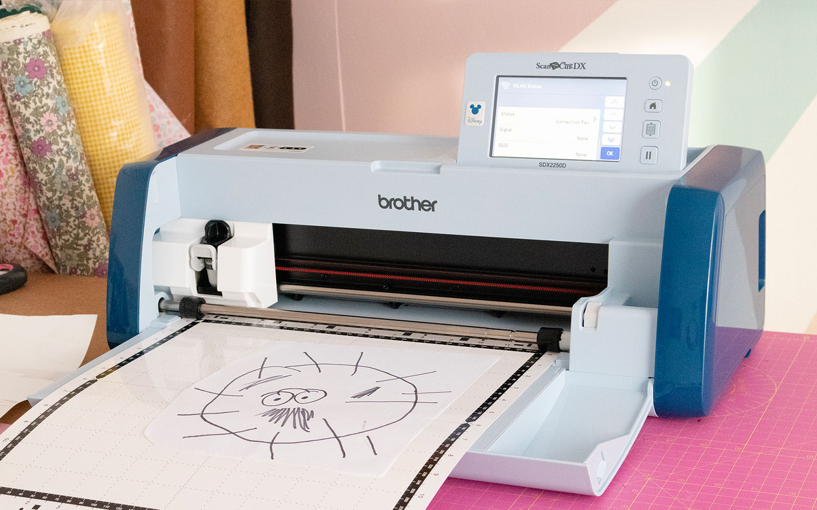 ScanNCut machine met een snijmat in de invoer en een tekening op de snijmat.