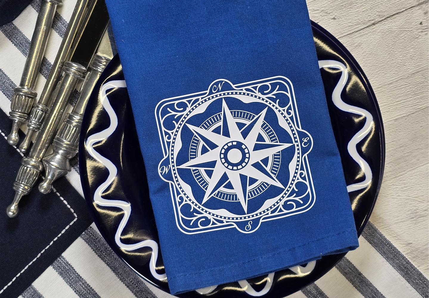 Blaue Serviette mit weißem maritimen Kompass-Motiv, geschnitten aus Thermotransferfolie mit ScanNCut
