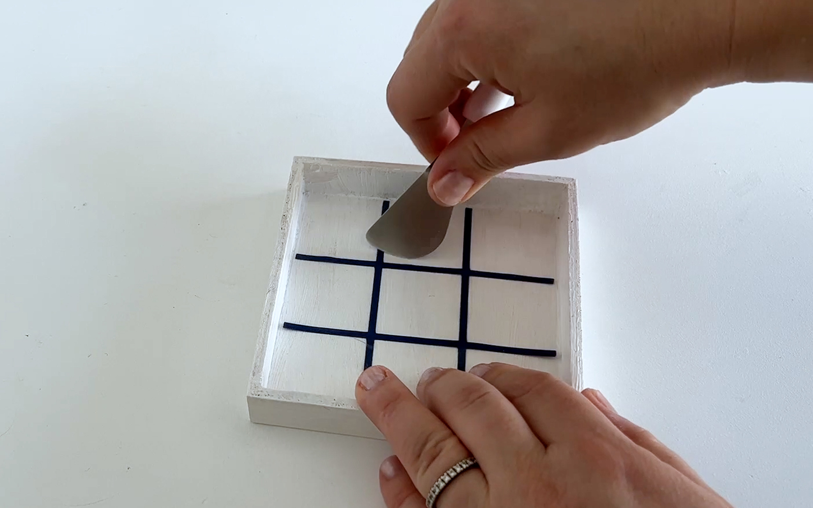 Vinyl grid being attached to box to make Tic-tac-toe travel set designed by missredfox