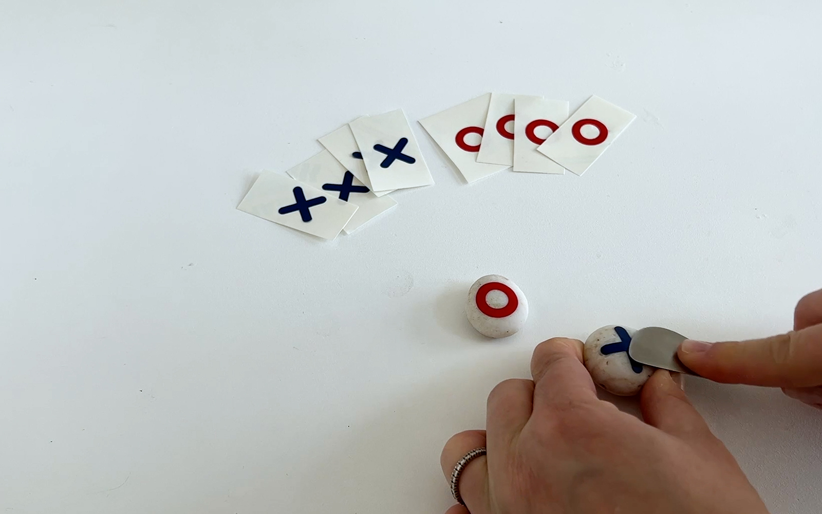 Blauw vinyl X motief wordt gladgestreken op grijze kiezel met ScanNCut spate