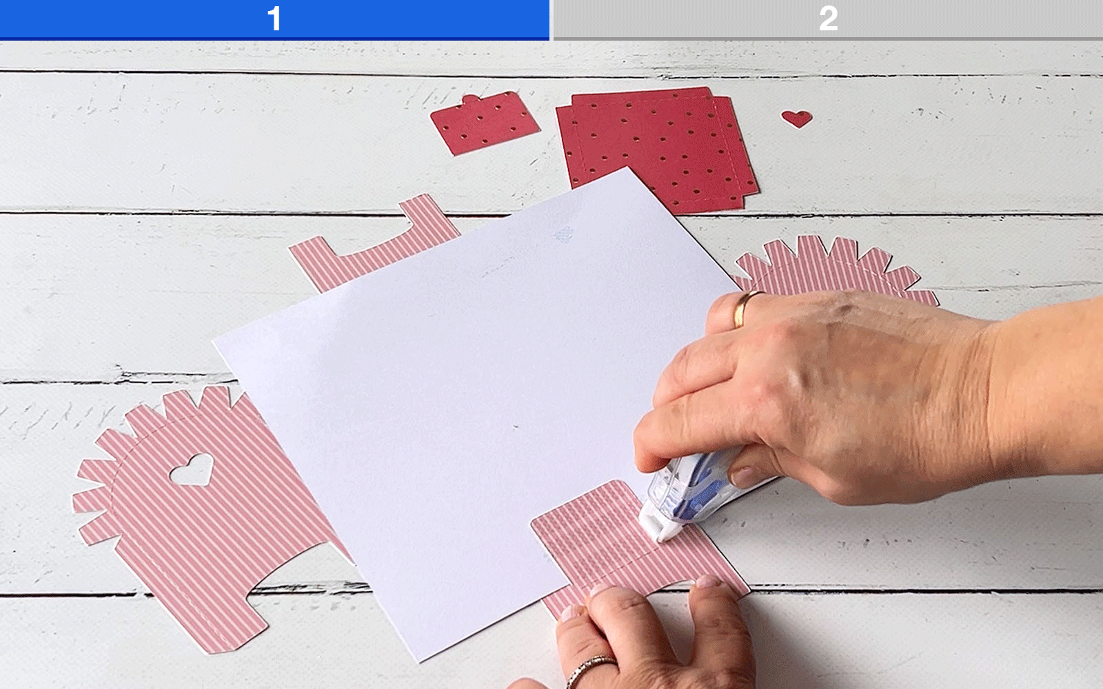 hand applying glue to card on white background