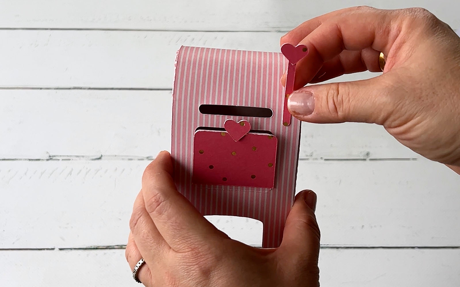Hands holding pink valentines box