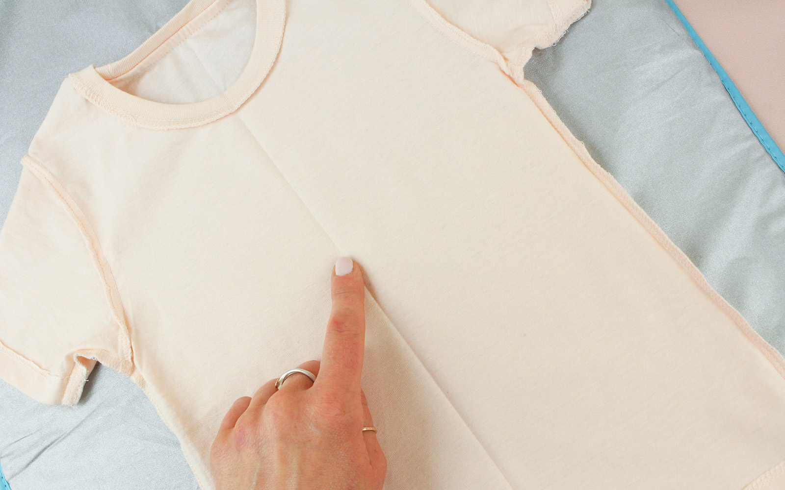 Main montrant un pli sur un T-shirt
