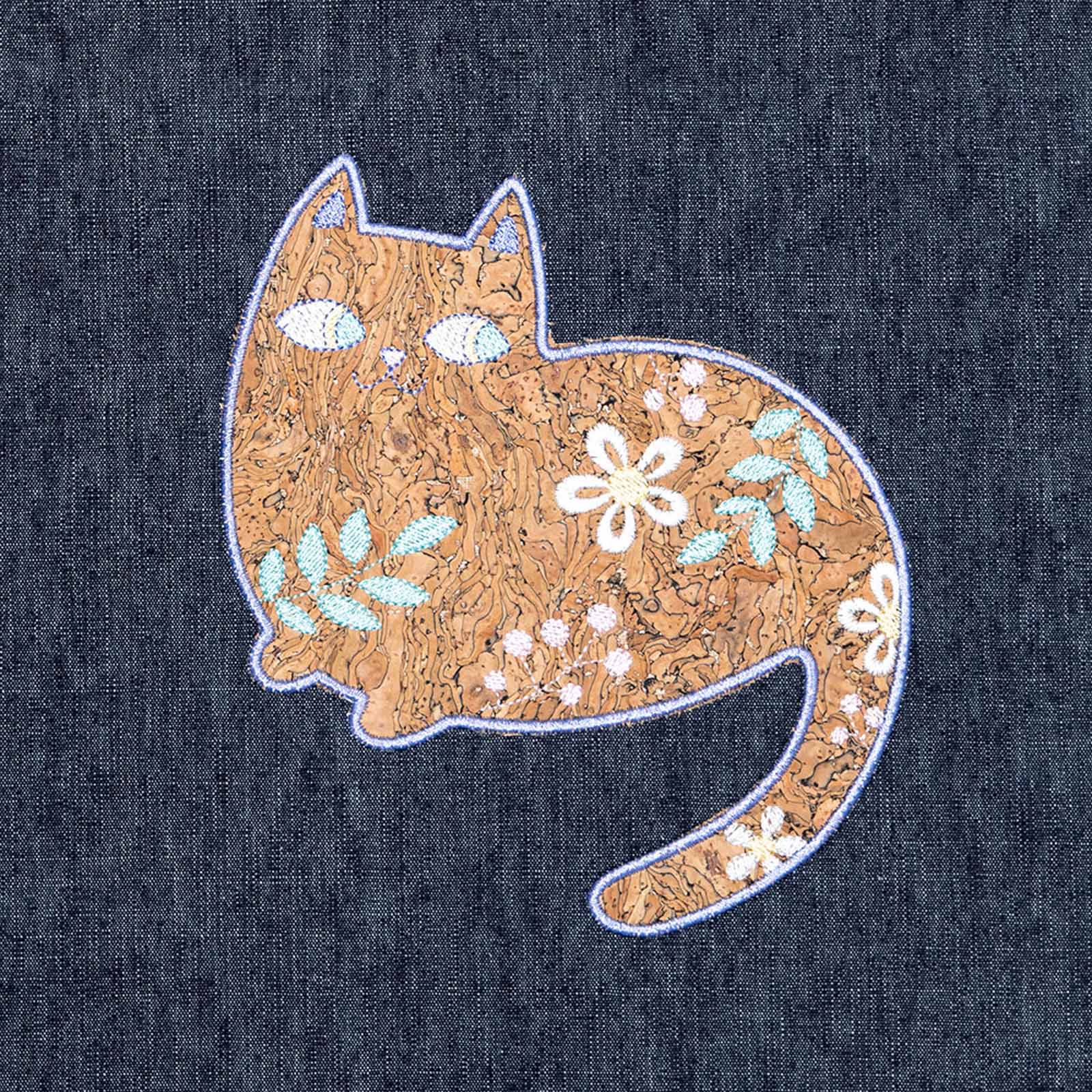 cork appliqué cartoon cat standing up with smile on dark blue denim