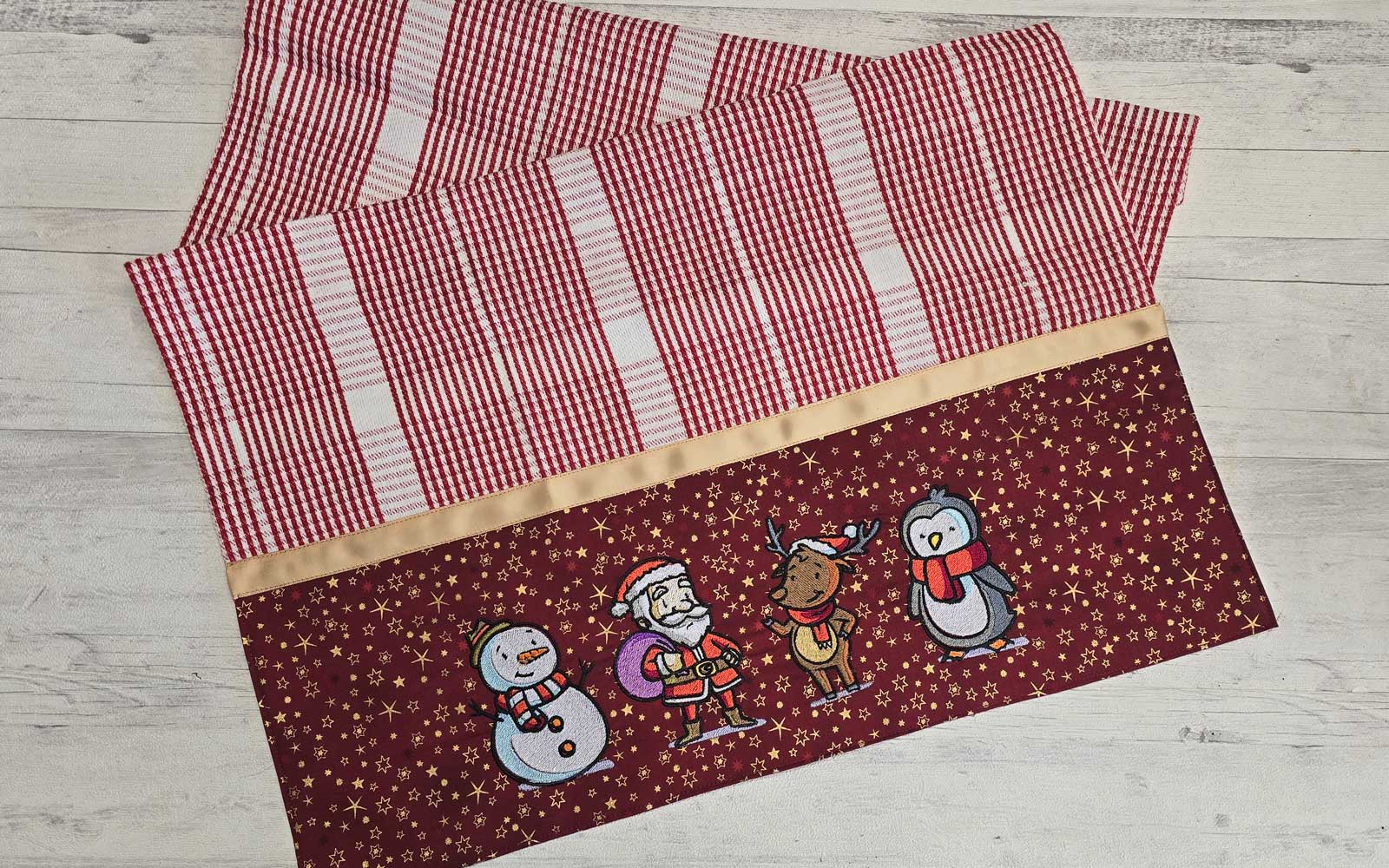 Rotes Geschirrtuch mit gestickten Weihnachtszeichen 