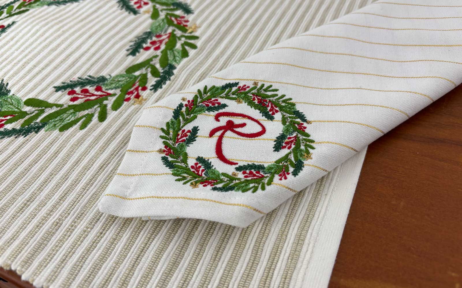 Une serviette de table avec une petite broderie de couronne de Noël