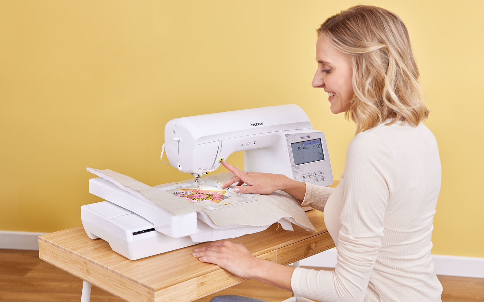 Woman using a Brother embroidery machine on a fabric project