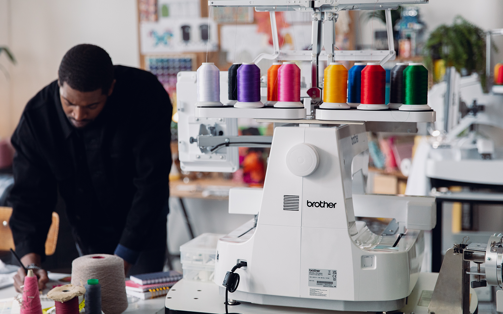 Man working with Brother PR1055X embroidery machine, ideal for both business and hobby use