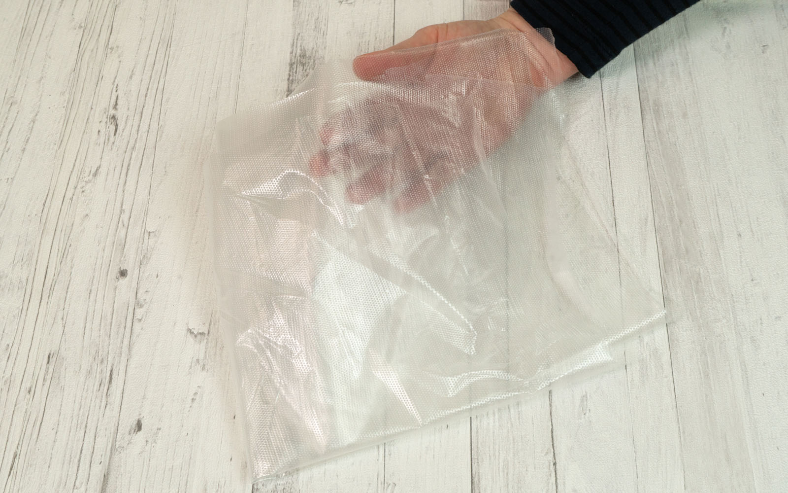 Transparent stabilizer and woman’s hand on wooden background