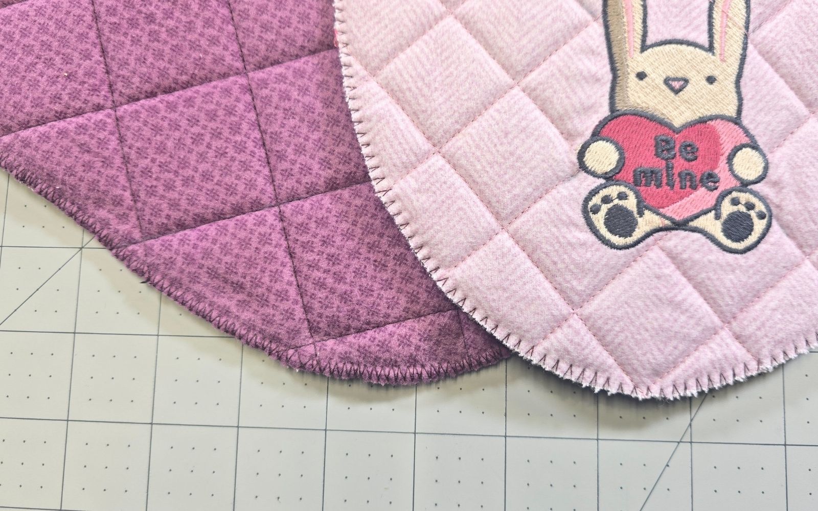 Tissu matelassé rose et violet avec broderie.