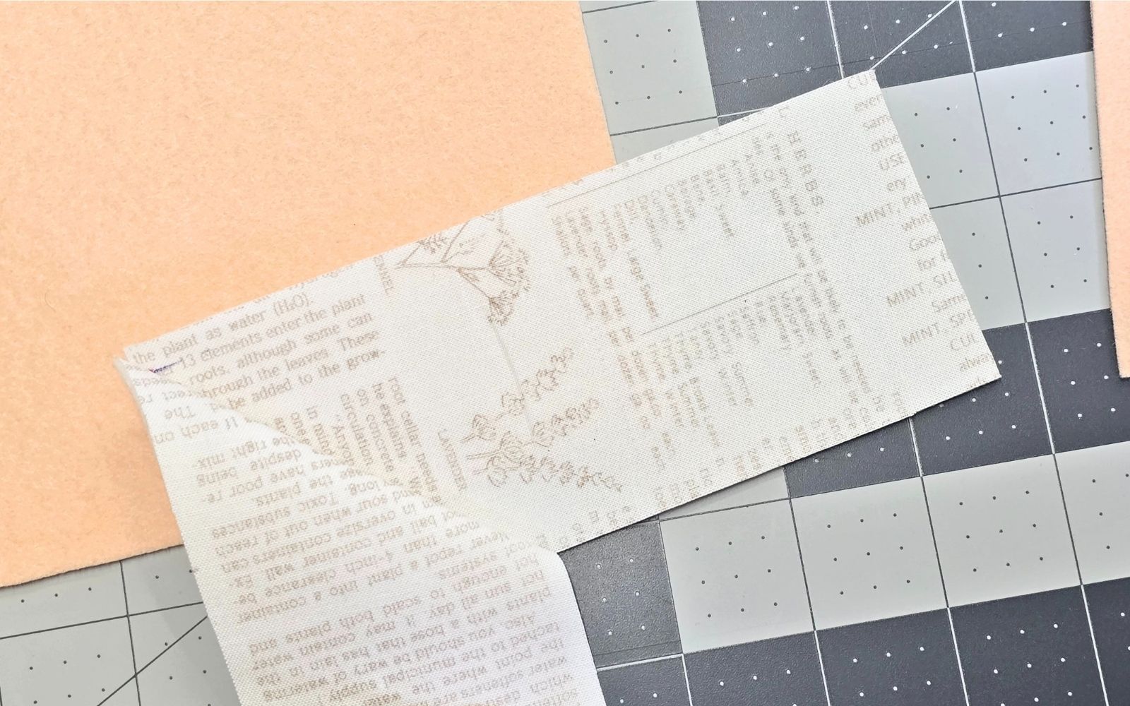 bande de tissu imprimé sur fond gris et pêche.