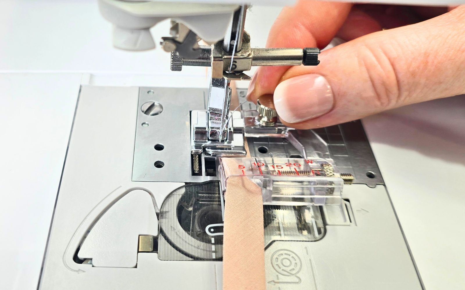 Regolazione manuale del piedino regolabile per bordature sulla macchina per cucire