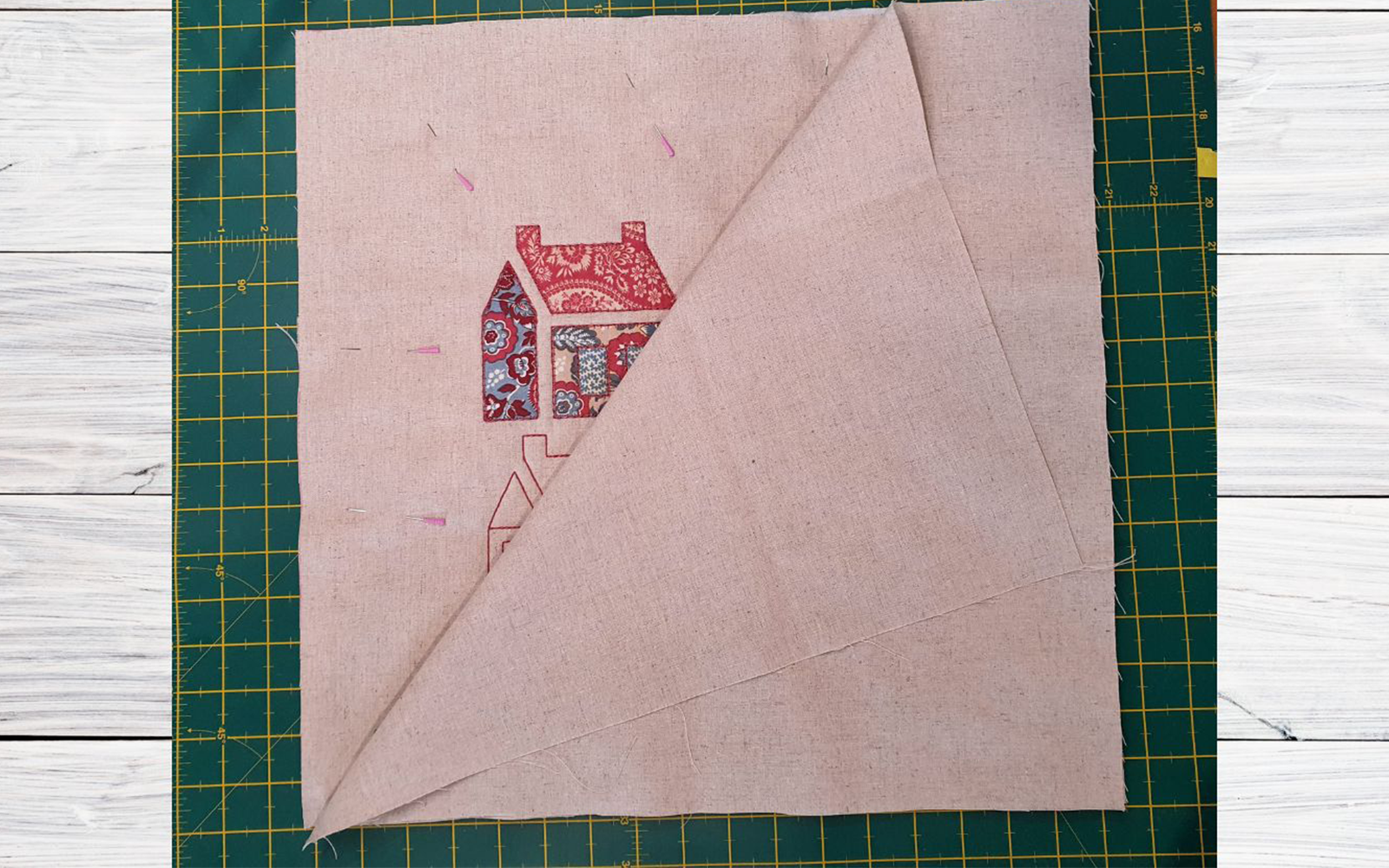 linen square with appliqué schoolhouse on green cutting mat