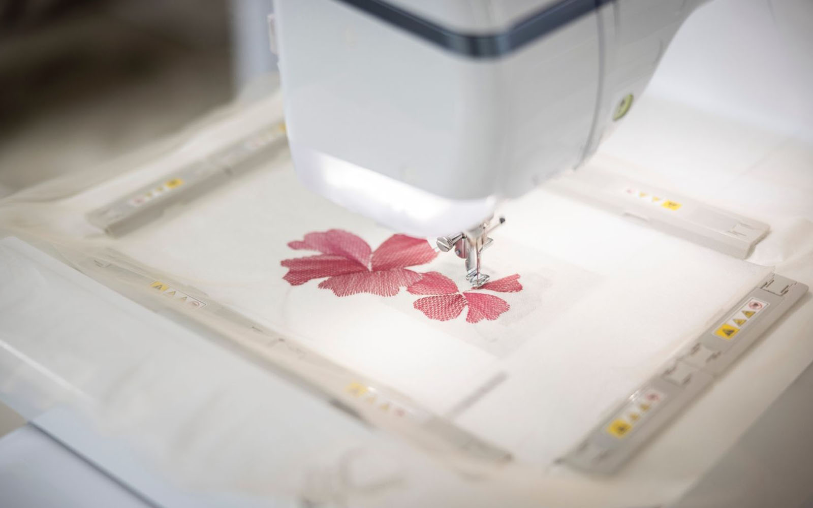 Machine à broder Brother brodant une fleur sur du tulle