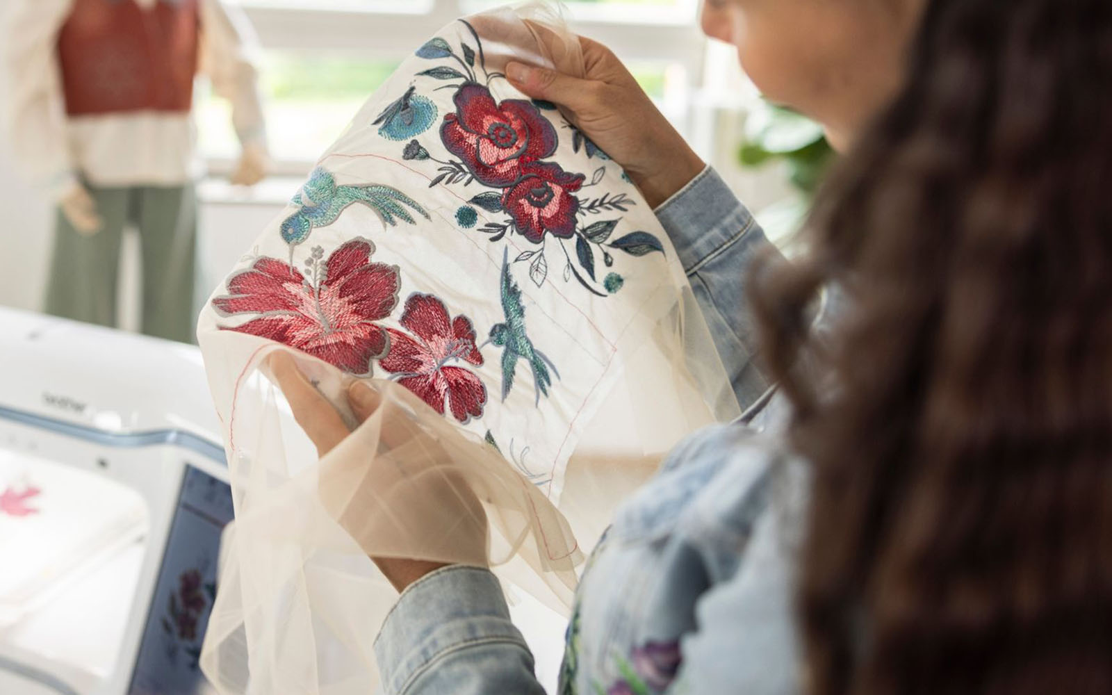 Vrouw houdt geborduurde tule met bloem vast