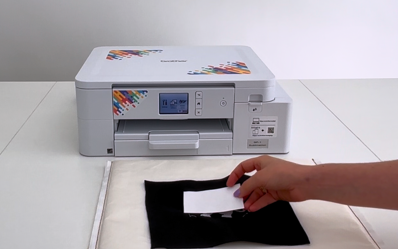 Hand places printed design onto white embroidery design 