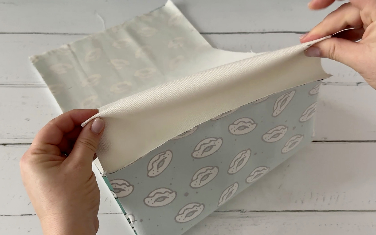 finger pressing seams of fabric book cover before sewing