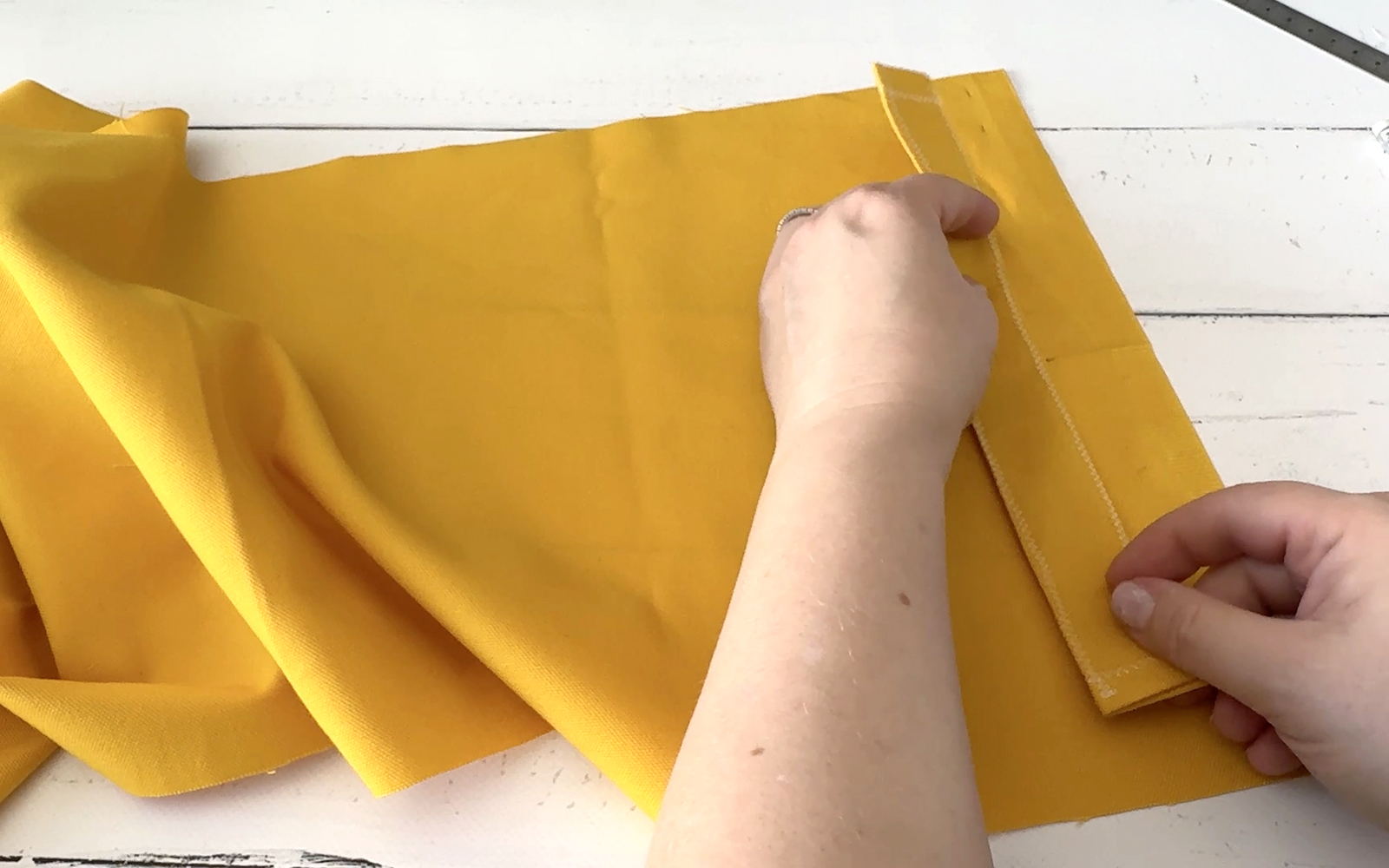 Placing yellow fabric sleeve on yellow lining fabric