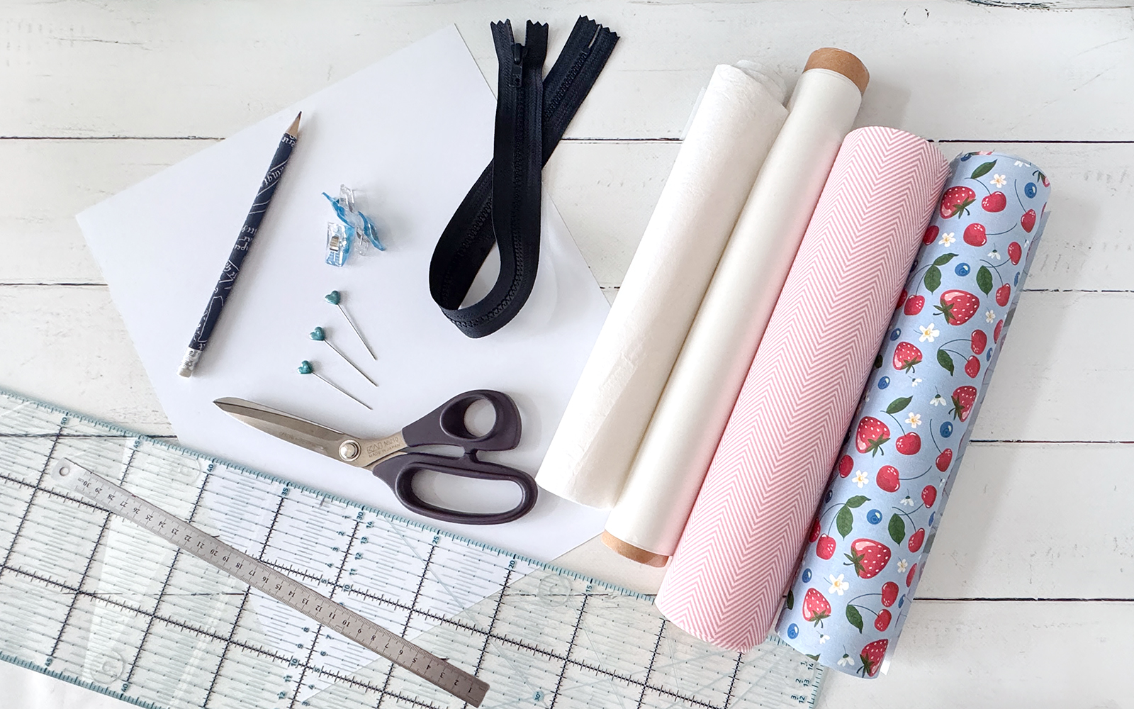 Rolls of fabric and tools to make a pencil case.