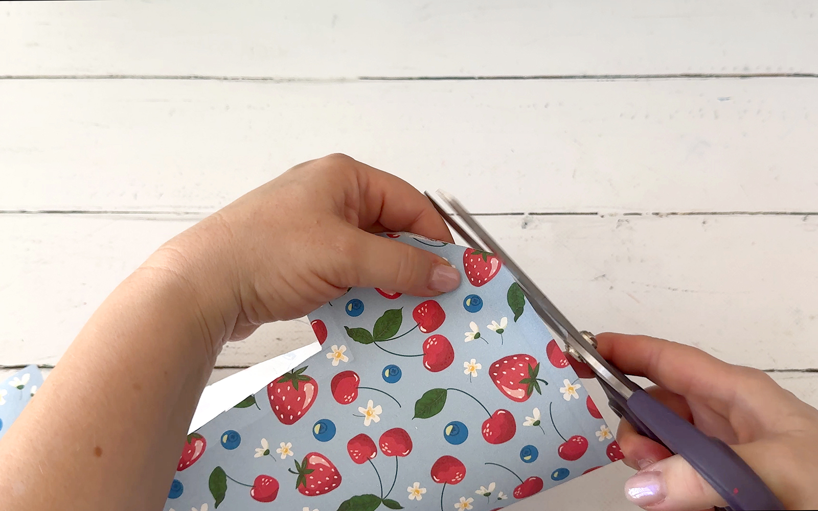 Hand cutting corner of fabric with scissors