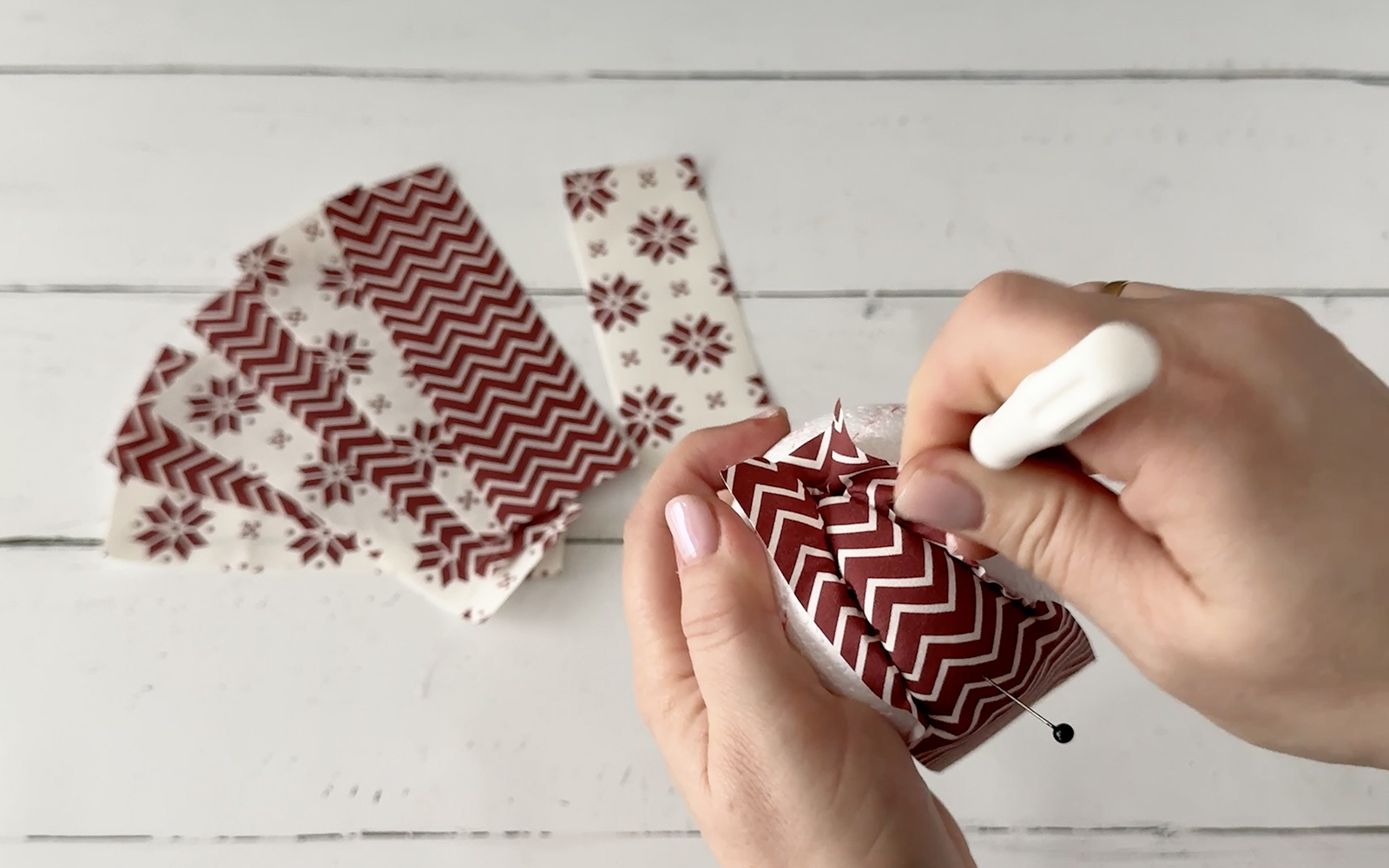 Using screwdriver to push fabric into Styrofoam ball