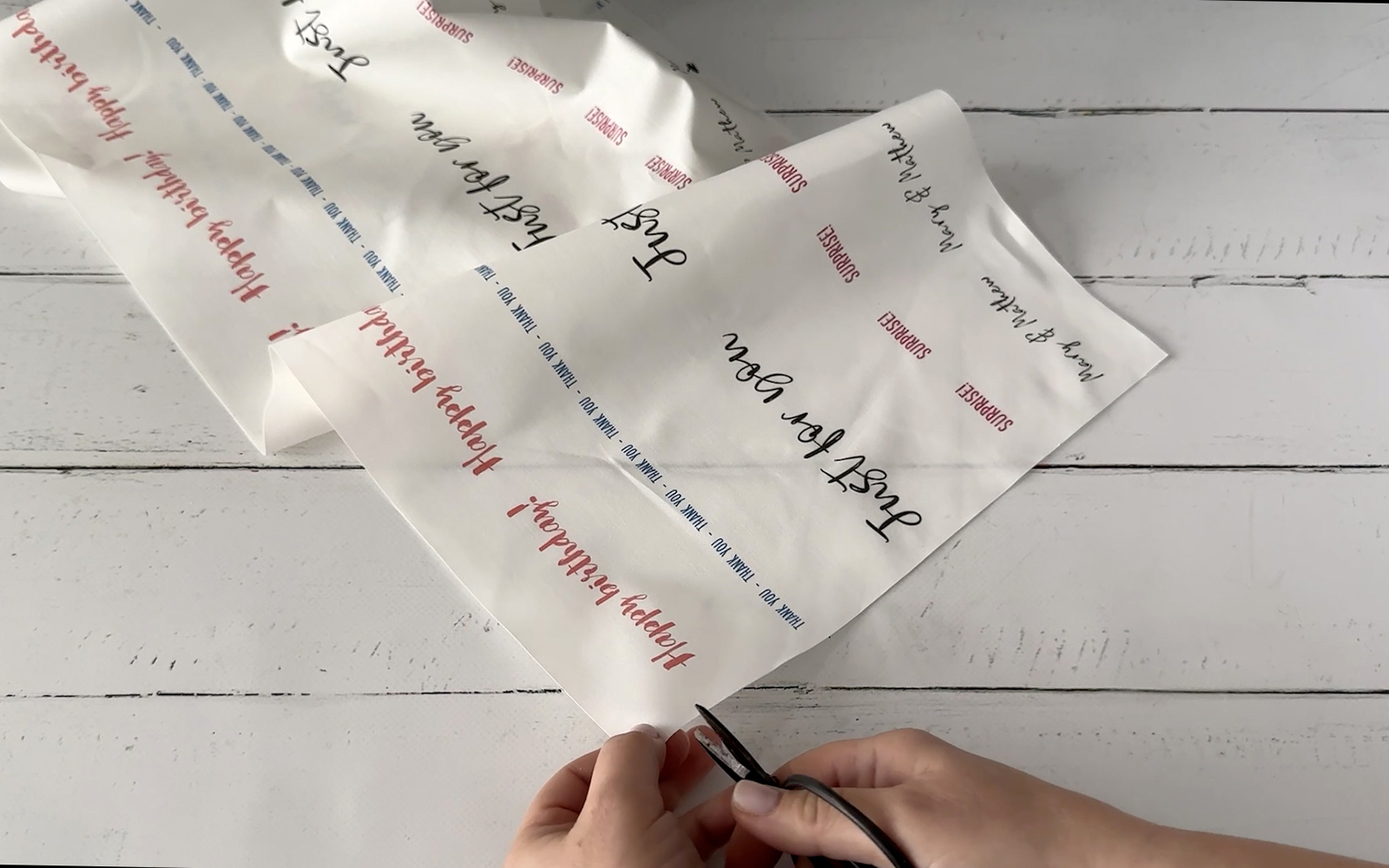 Mains découpant une feuille imprimée en rubans