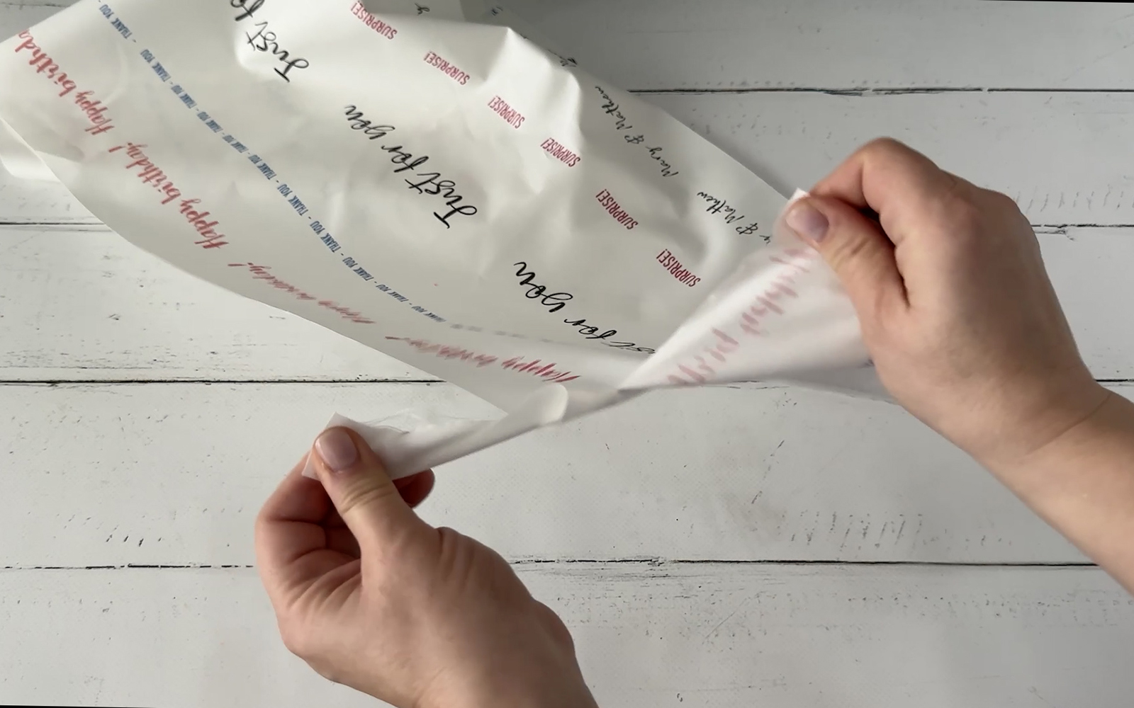 hands ripping printed sheet into ribbons    