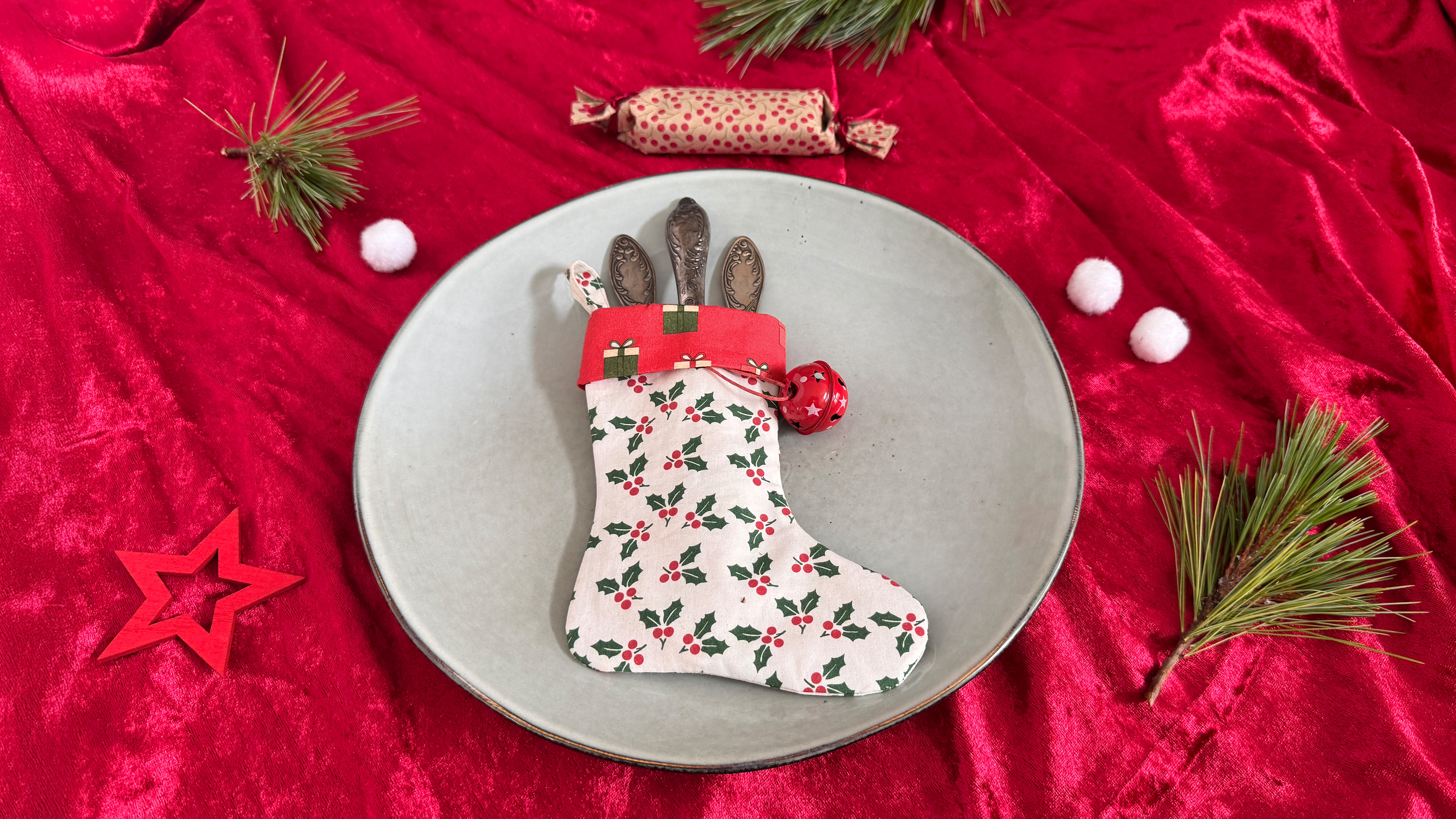 Printed stocking with cutlery inside on plate on red fabric