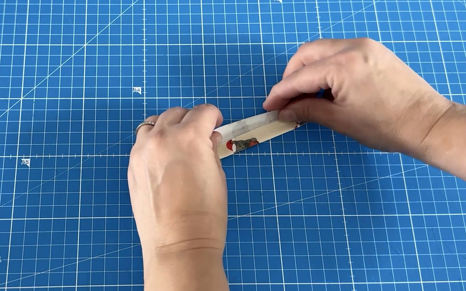 Hand folds small rectangular shape to the centre