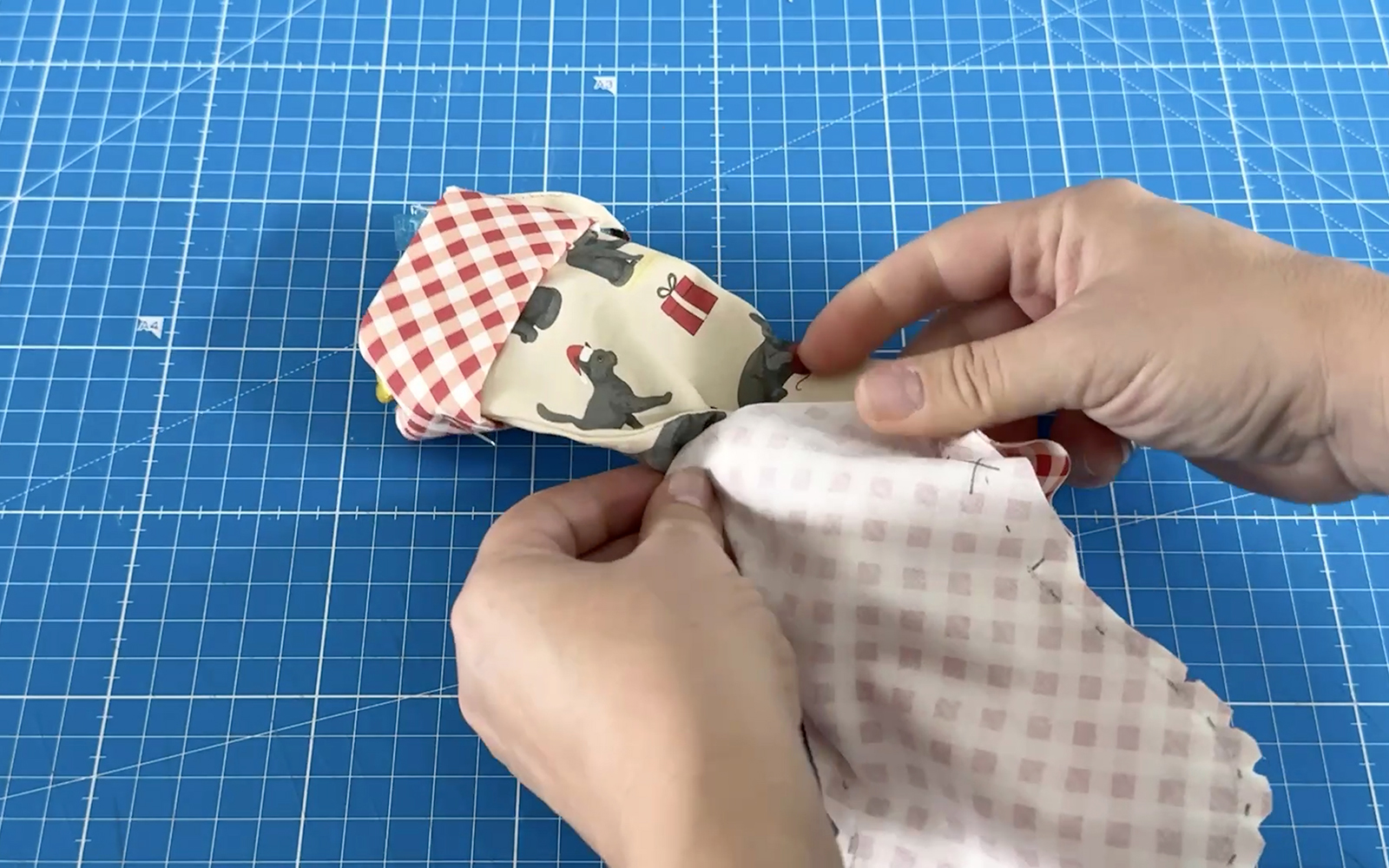 Pieces of fabric printed stocking being placed together 