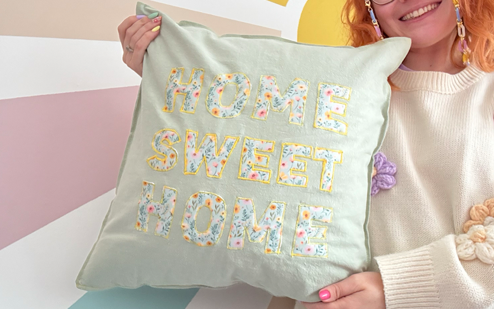 Paige Joanna tenant le coussin appliqué ”Home Sweet Home”.
