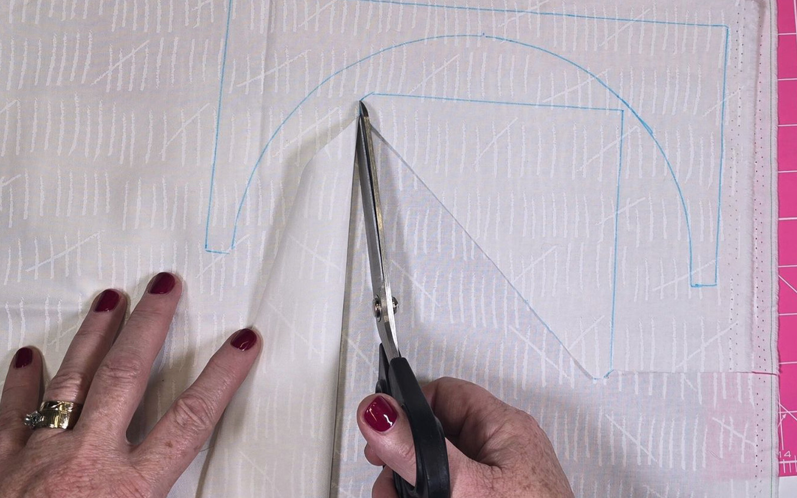 Schere schneidet Quiltteile aus weißem Baumwollstoff