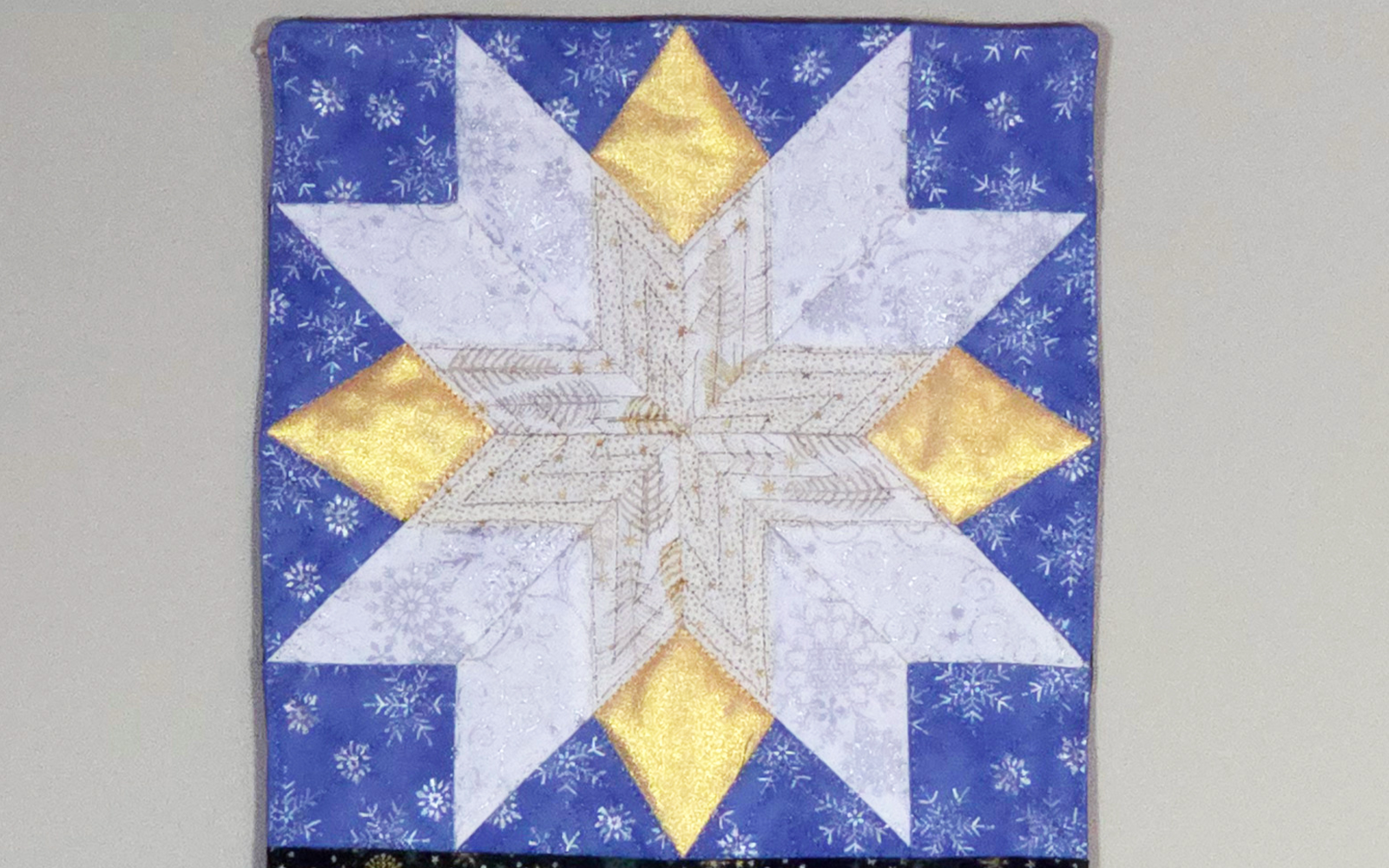Blauw, wit en goud stralend stervormig quiltblok.
