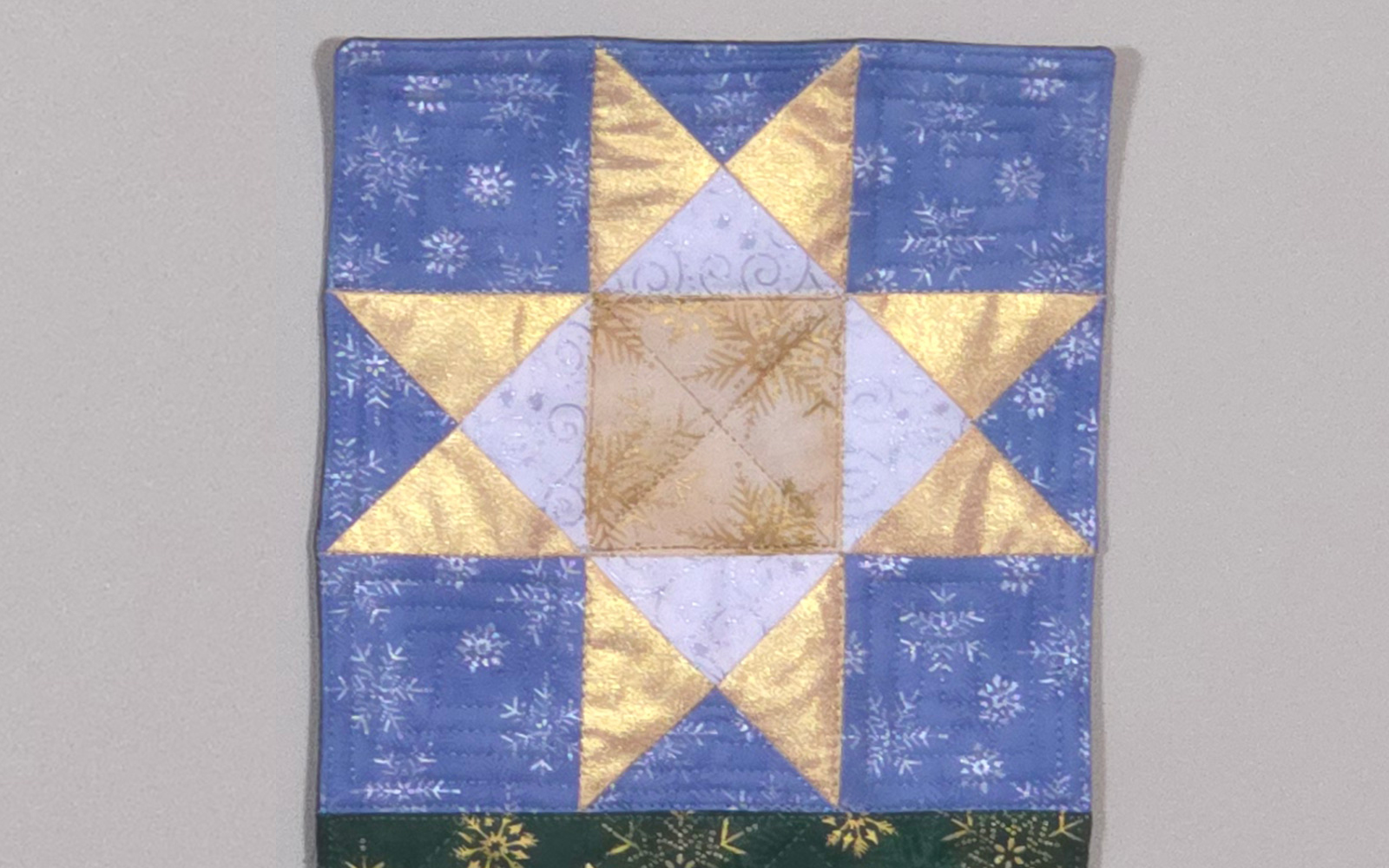 Blocco trapuntato stella seghettata blu, bianco e oro.