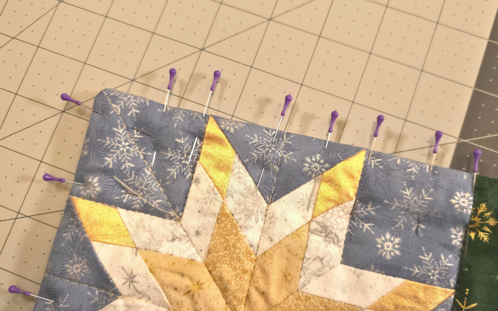 blue and yellow star quilt block with purple pins.