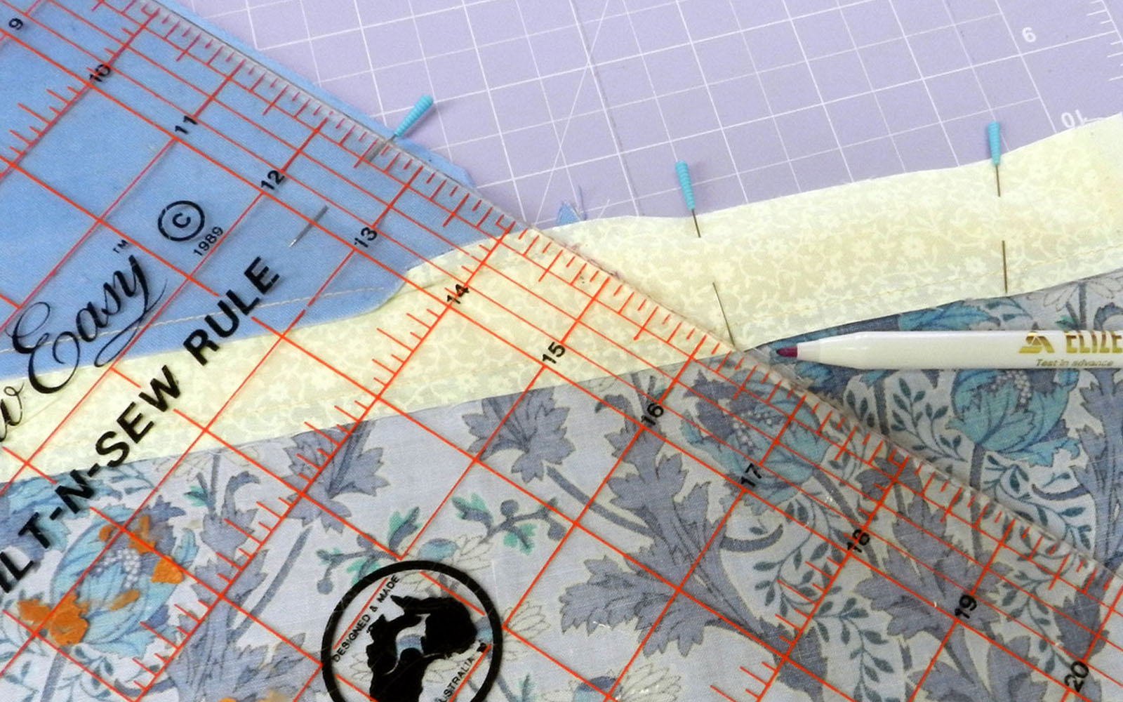 Ruler, pen and fabric marked with pins